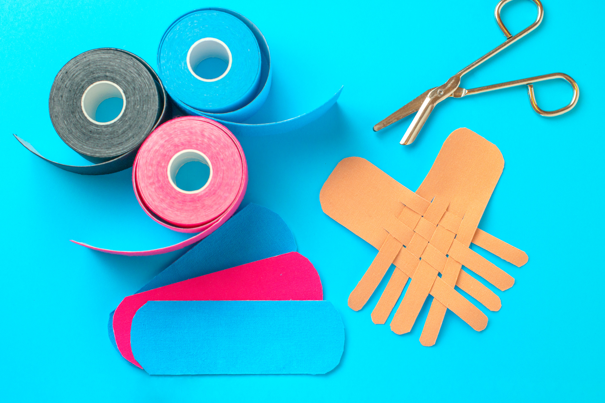 colored kinesiotapes with a pair of scissors